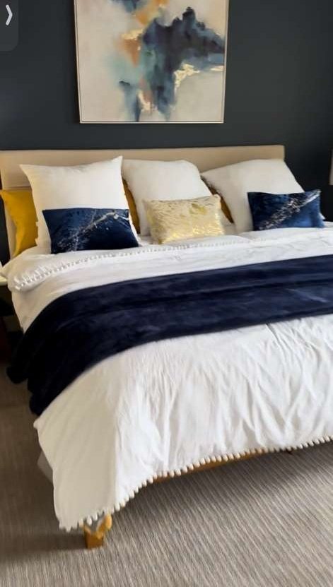Furnished bedroom with a dark feature wall and layered bedding