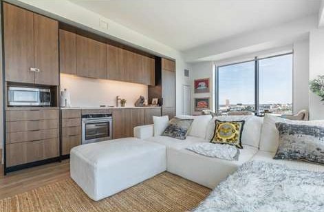 Open-plan studio with a fitted kitchen, sofa and floor-to-ceiling windows