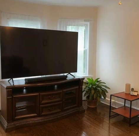 Living area with a large television on a wooden media unit